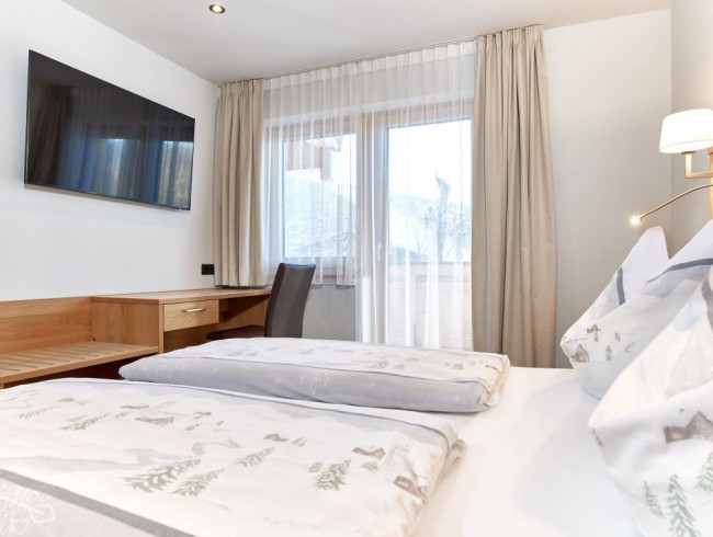 Schlafzimmer mit Doppelbett, Flat-TV und Balkon
