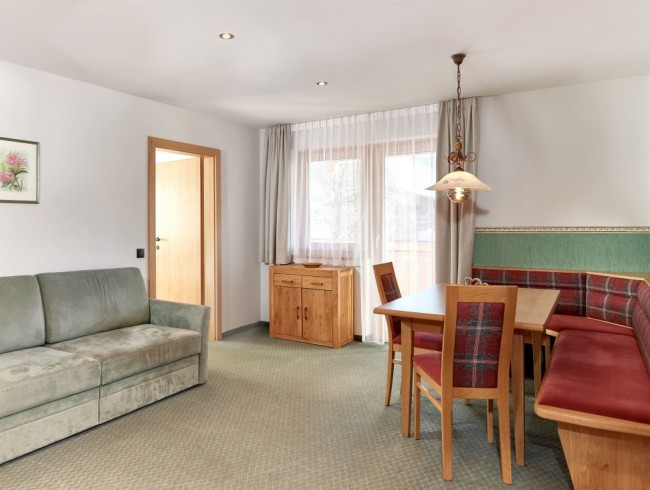 Ger&auml;umiges Wohnzimmer mit Couch und Esstisch